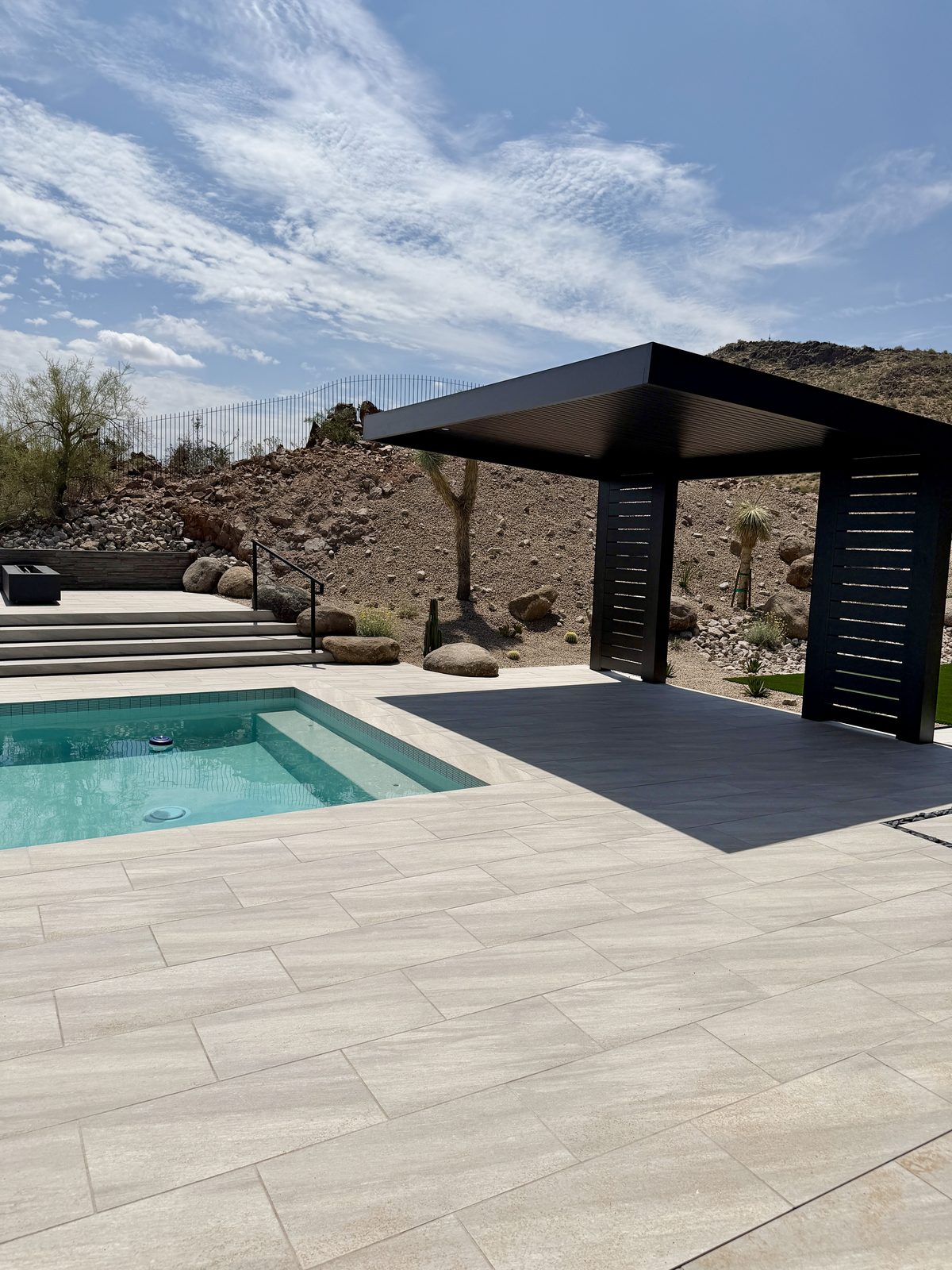 Pool deck with louvered shade structure and linear fire feature